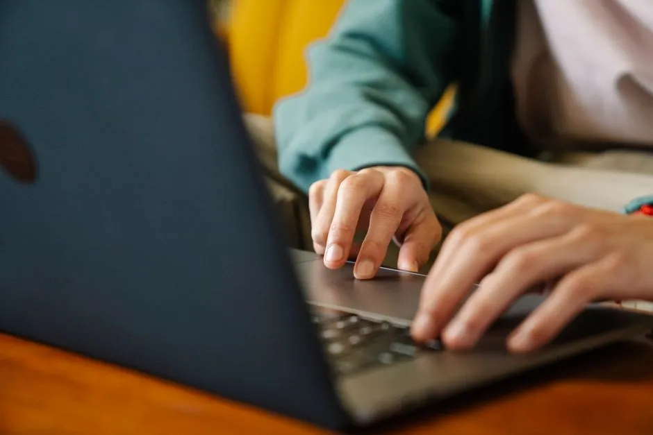 Close-up of hands typing on a laptop keyboard, illustrating editing a document template online