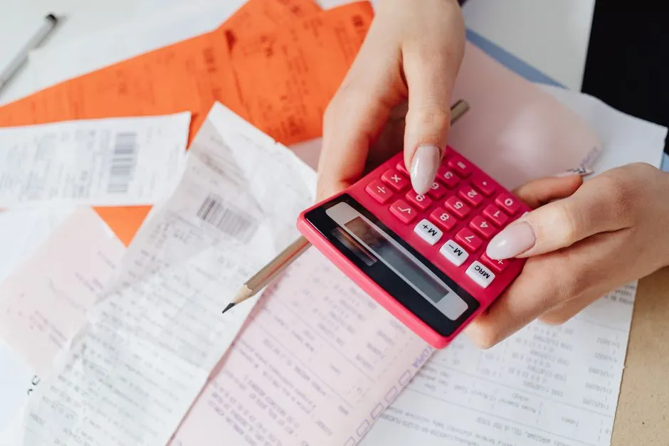 Close-up of a calculator and paperwork on a desk, illustrating invoice math and bookkeeping